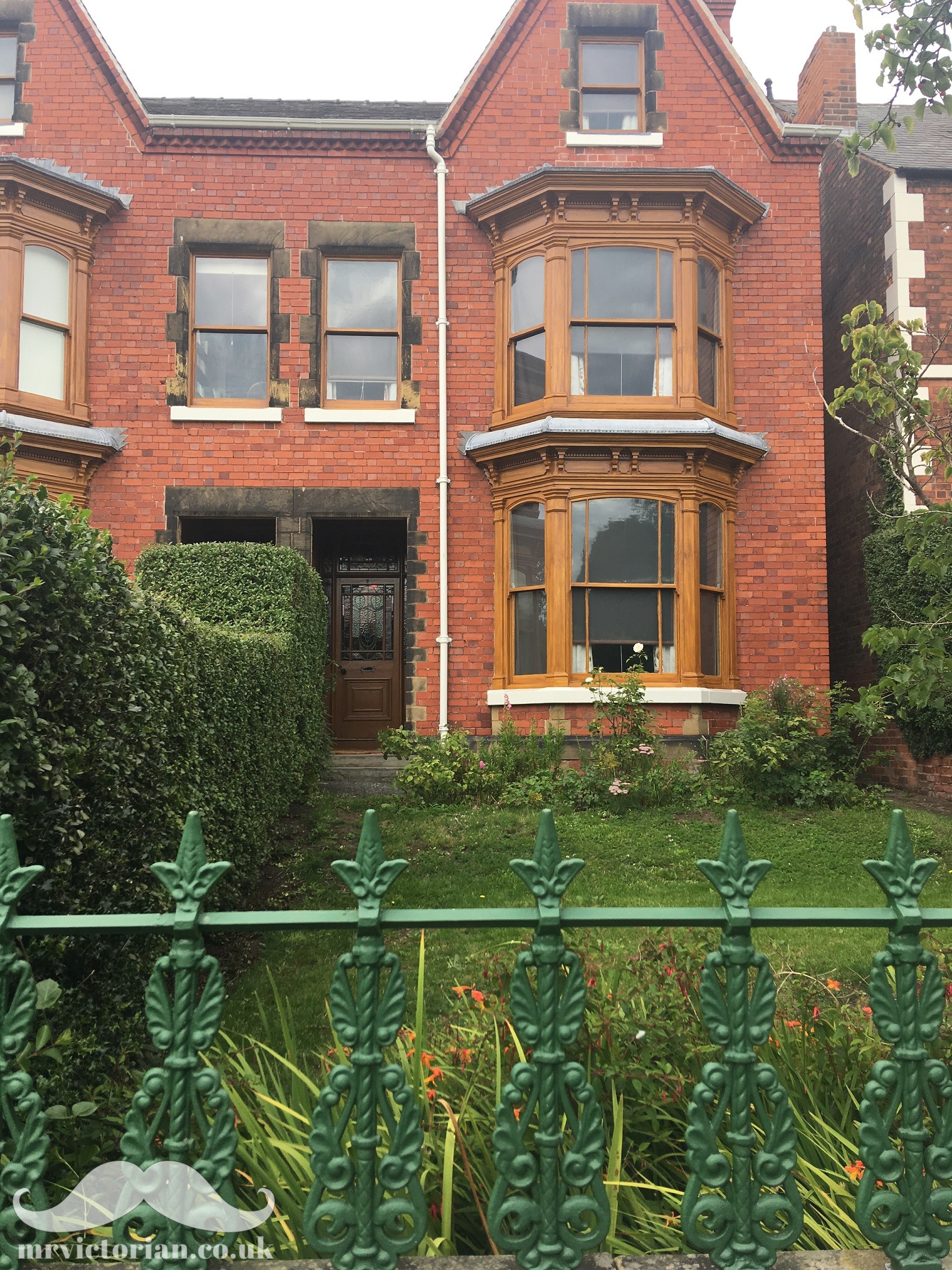 Mr Straw's House showing woodgrained windows and green Edwardian railings
