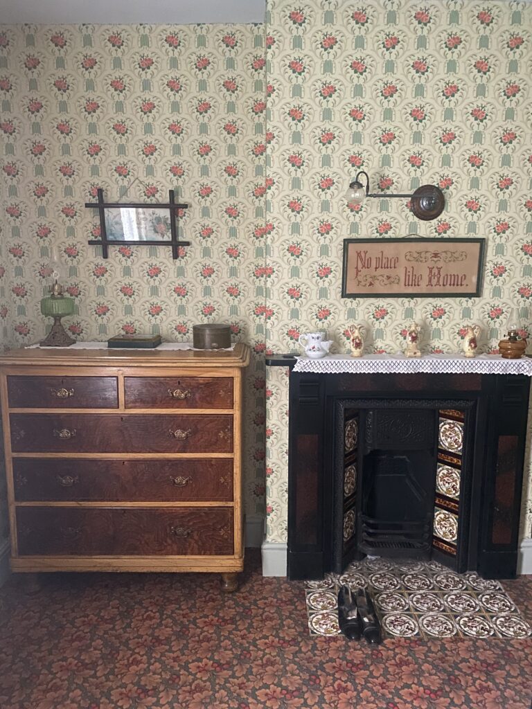Victorian bedroom showing antique items including fireplace, chest of drawers and ornaments