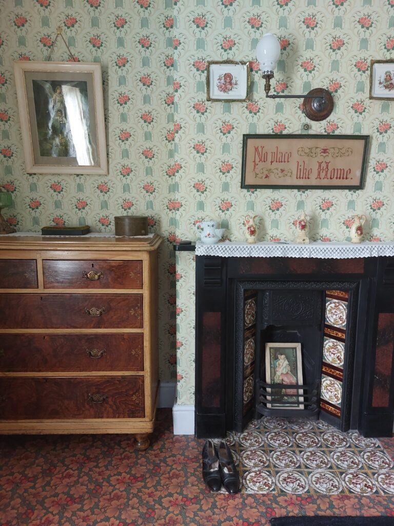 Victorian bedroom with Edwardian wallpaper and original fireplace 