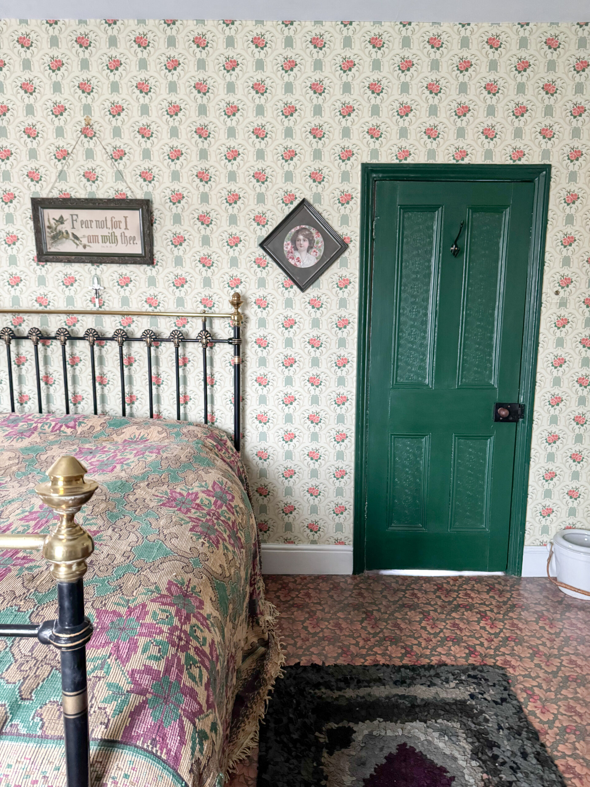 Victorian bedroom with recreated Edwardian wallpaper and brass and iron bed