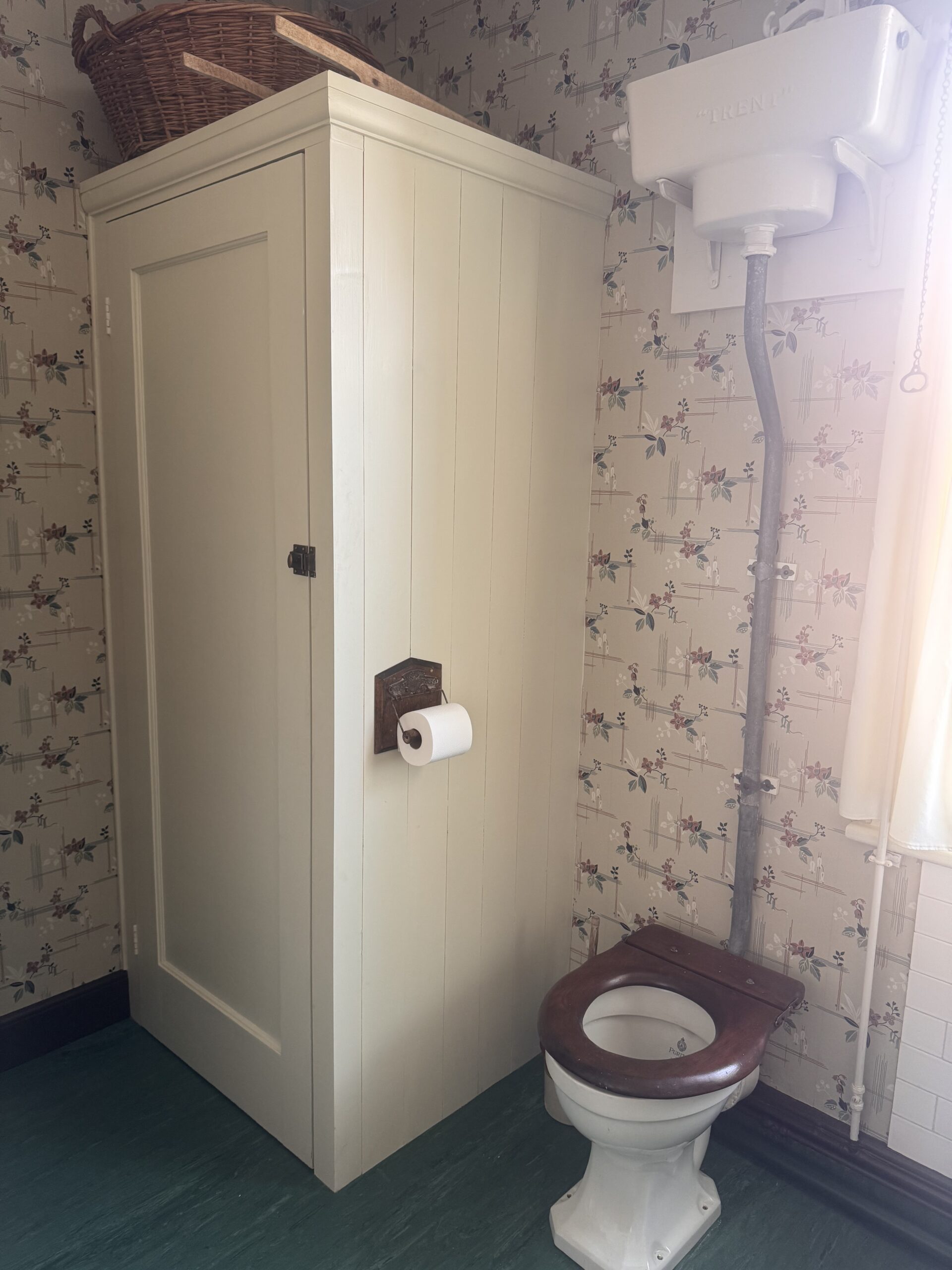 1930s high cistern toilet with corner cupboard next to it